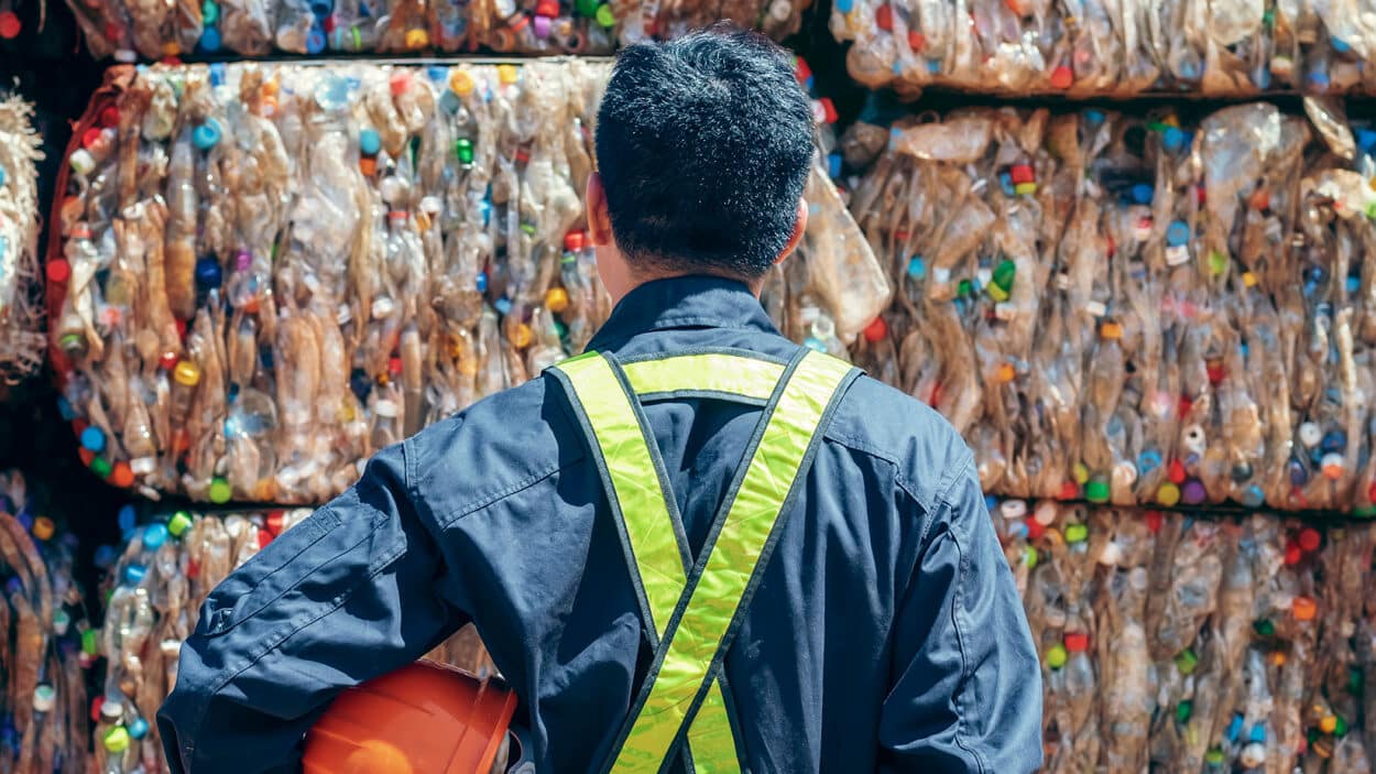 A man looking at a pile of rubbish.